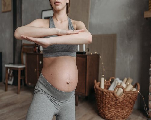 Woman practicing gentle stretching at home during sunset